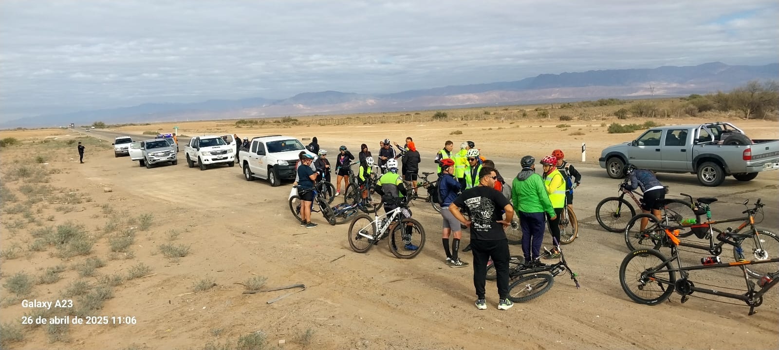 El grupo Atreverse hace una pausa sobre un camino de tierra rodeados de paisajes abiertos y montañas
